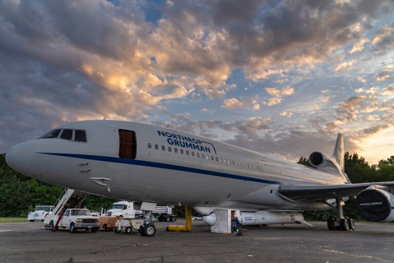 An airplane with a rocket attached to the bottom of its fuselage